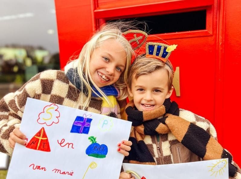 Kinderen met hun Sint-tekening aan de rode brievenbus
